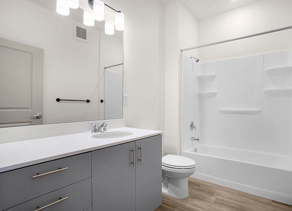 A white bathroom with a sink, toilet, and bathtub.