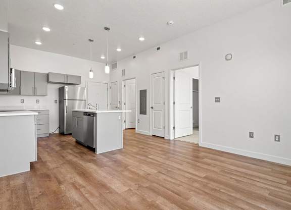 an open kitchen and living room with a hard wood floor