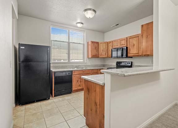 a kitchen with a counter top and a black refrigerator