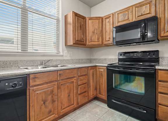 a kitchen with black appliances and wooden cabinets