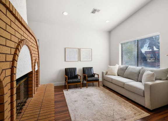 a living room with a couch and a brick fireplace