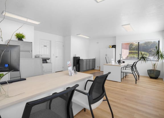 a living room and kitchen with a desk and chairs