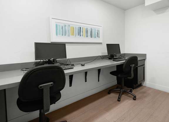 a desk with two computers on it in a room
