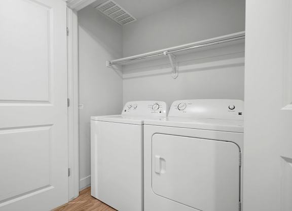 a laundry room with a washer and dryer and a white door