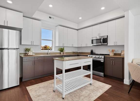 a kitchen with white cabinets and a island in the middle