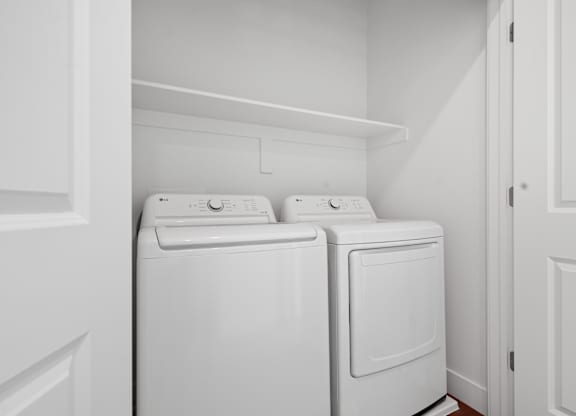 a washer and dryer in a laundry room with white walls and white doors