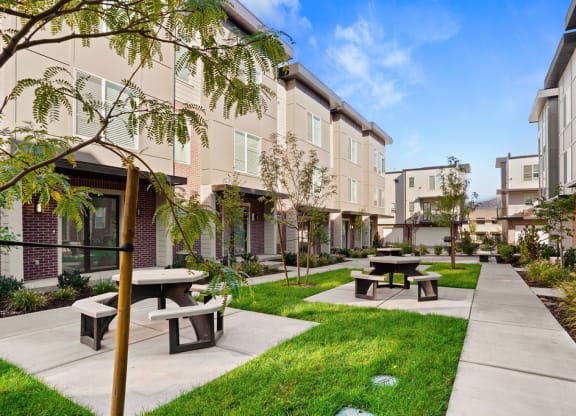 a courtyard with benches and picnic tables at Greens by Lotus Townhomes, Ogden
