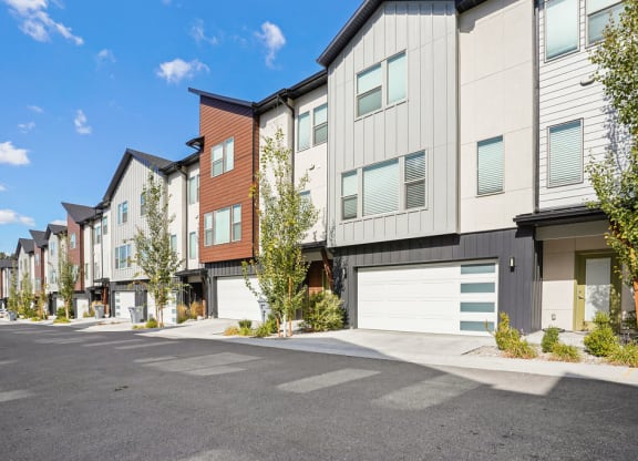 an empty parking lot in front of a row of apartment buildings