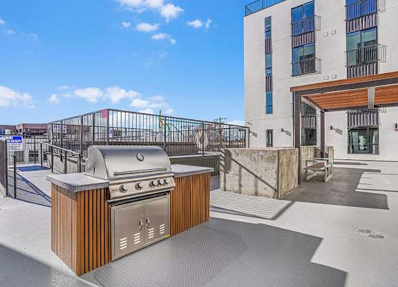 A modern outdoor kitchen with a grill and sink.