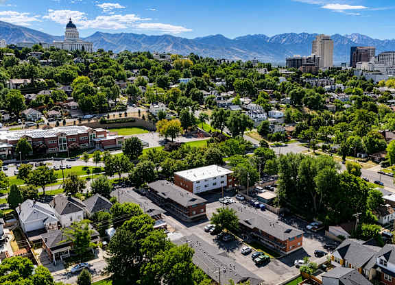 A cityscape with a mix of residential and commercial buildings, surrounded by mountains.