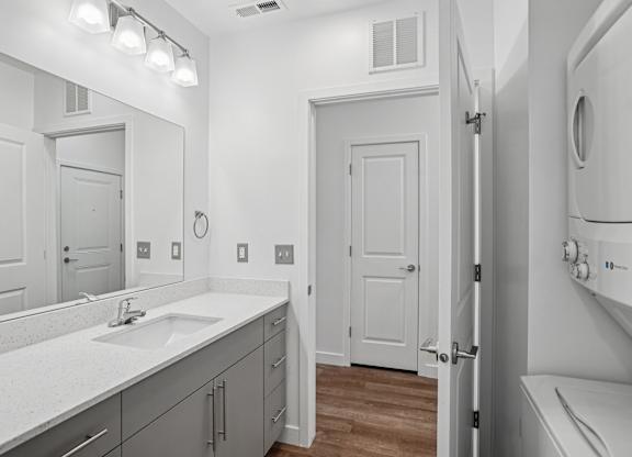 A bathroom with a sink, mirror, and toilet.