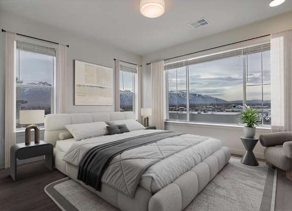 A bedroom with a large bed and a view of the mountains outside the window.