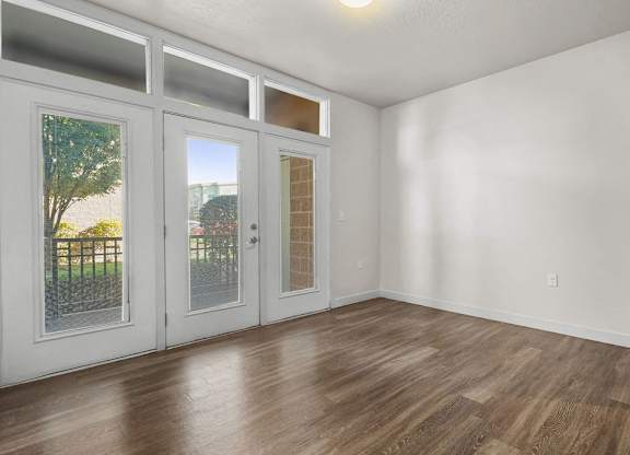 an empty living room with white walls and wood floors