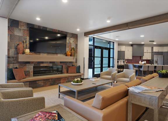 A modern living room with a stone fireplace and a large flat screen TV.