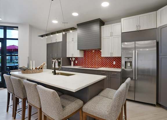 A modern kitchen with a large island and stainless steel appliances.