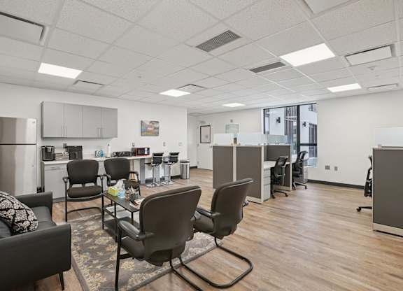 A modern office space with a couch, chairs, and a coffee table.