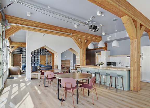 A kitchen with a dining table and chairs.