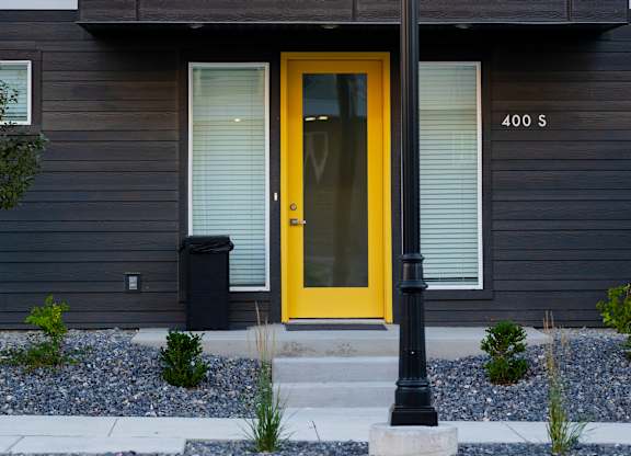 A building with a yellow door and a black lamp post in front.