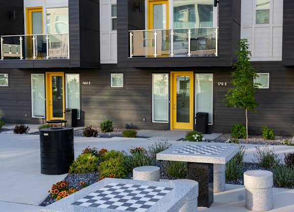 A chess board is set up on a table outside a building.