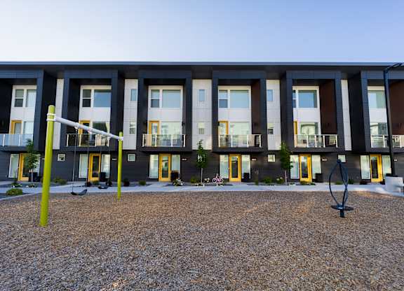 A modern building with a grey facade and yellow accents.