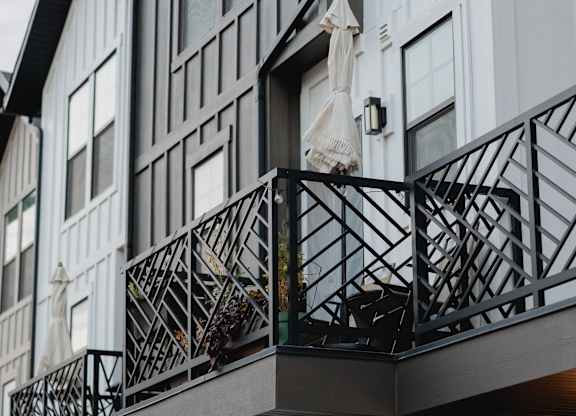 A balcony with a black railing and a white towel hanging on it.