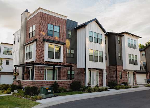 A row of modern townhouses with brick and siding exteriors.