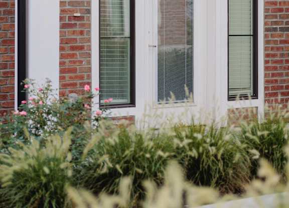 A white house with a glass door and a brick wall.