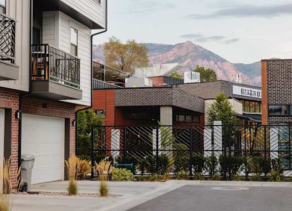 A street view of a residential area with houses and a mountain in the background.
