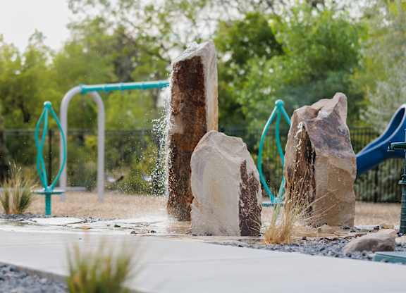 A water fountain in a park splashes water into the air.