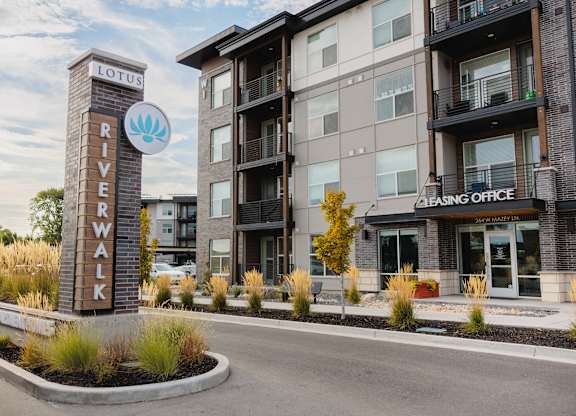 A sign for Lotus River Walk in front of a building.