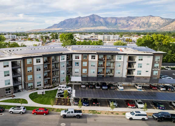 A large apartment complex with a parking lot in front.