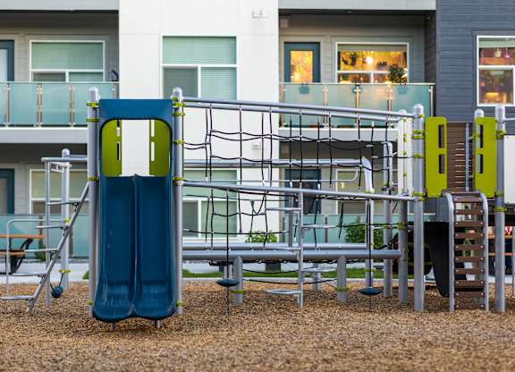 A playground with a blue slide and a metal structure.