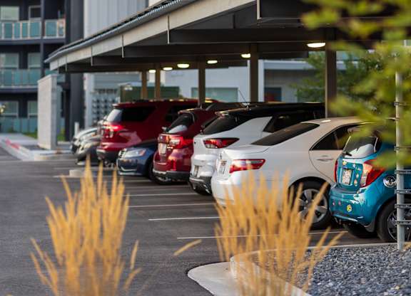 A parking lot with cars and a building in the background.