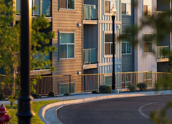 A modern apartment building with a curved driveway in front.