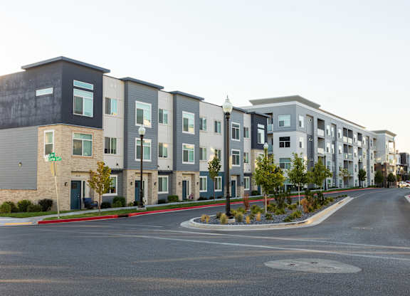A street view of apartment buildings with a roundabout in the foreground.