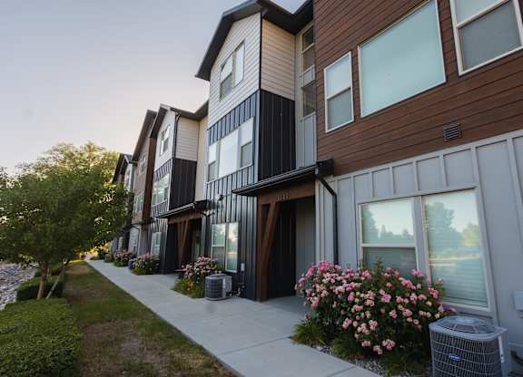 A row of modern townhouses with flower boxes on the front.