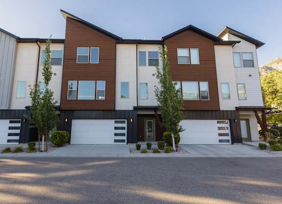A modern two-story residential building with a garage on the ground floor.