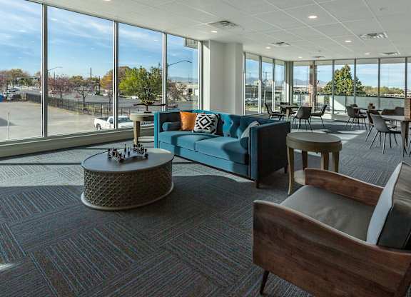 A modern living room with a large window overlooking a parking lot.
