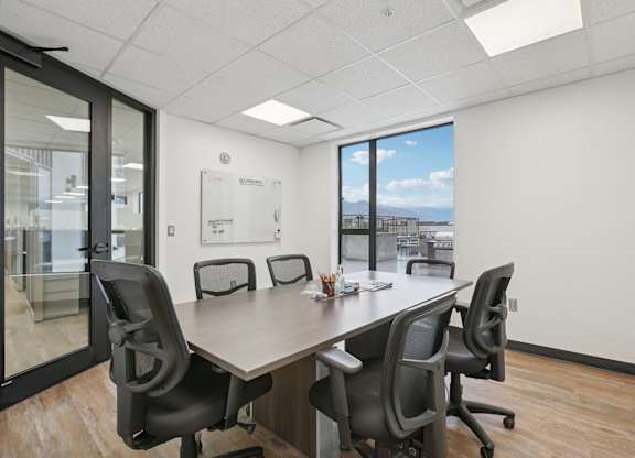 A conference room with a long table and chairs.