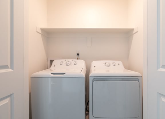 a washer and dryer in a laundry room at Current by Lotus, Ogden, 84401