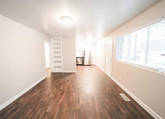 A room with wooden floors and a white wall.