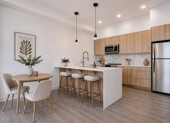 A modern kitchen with a dining table and chairs.