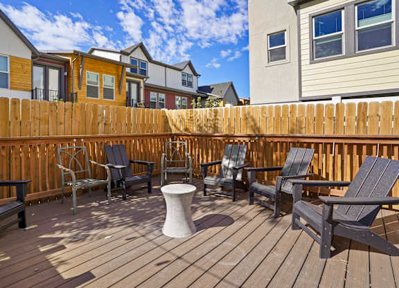 A wooden deck with chairs and a table.