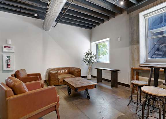 A room with brown leather furniture and a wooden table.