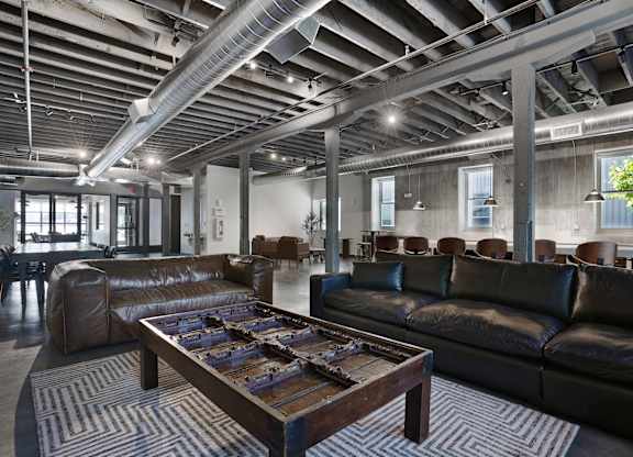 A large room with leather couches and a wooden coffee table.