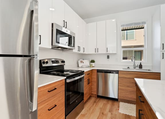 a kitchen with white cabinets and stainless steel appliances at Greens by Lotus Townhomes, Ogden, UT, Utah , 84403