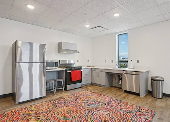 A kitchen with a refrigerator, stove, and sink.