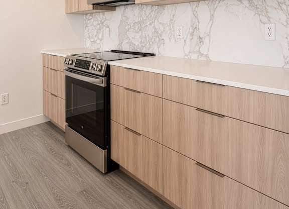 A kitchen with wooden cabinets and a black stove top oven.
