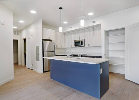 A kitchen with a blue island in the middle.