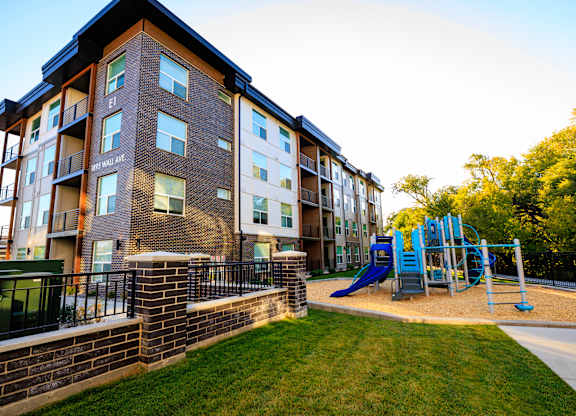 A large apartment building with a playground in front.